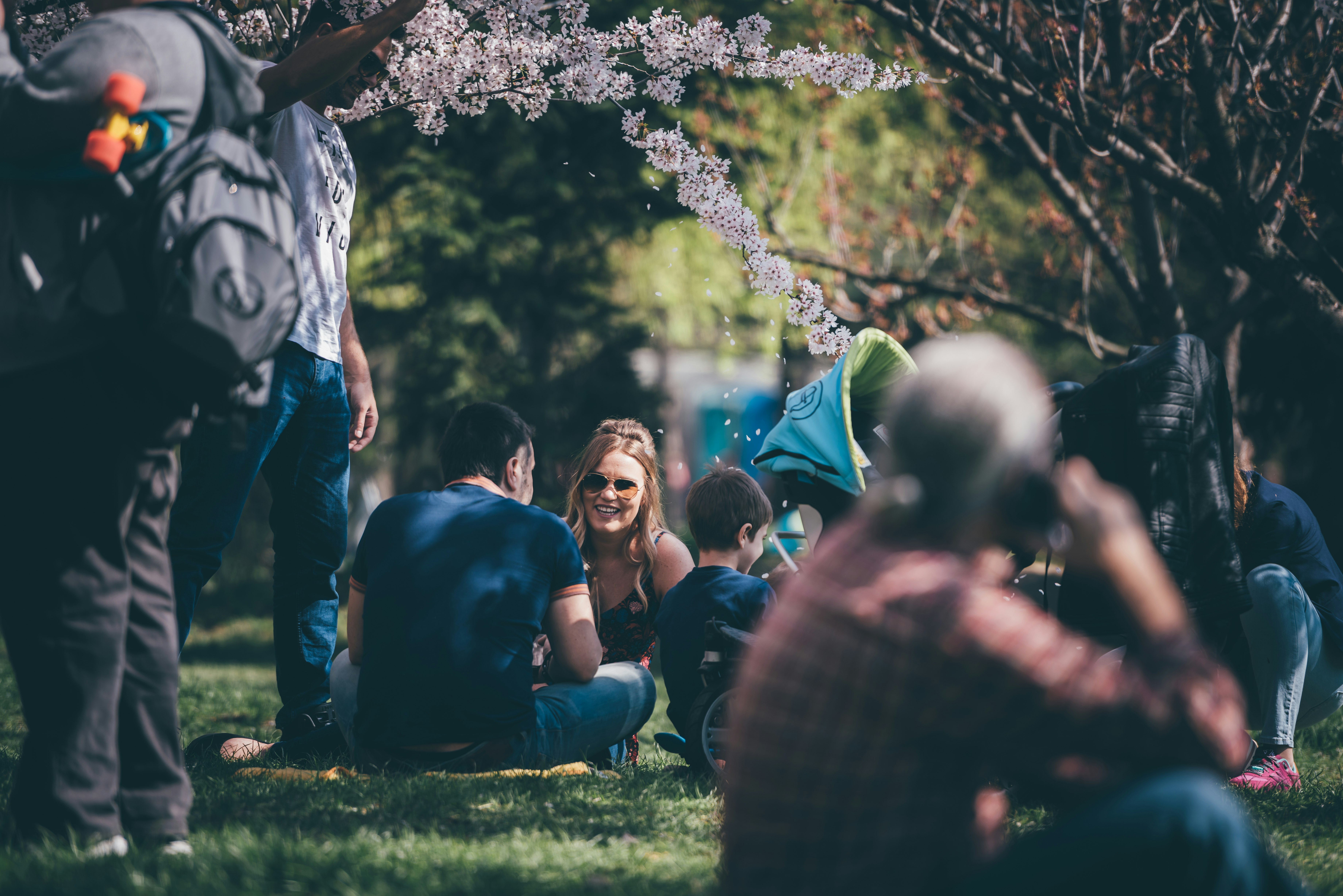 man and woman sitting on grass field during daytime